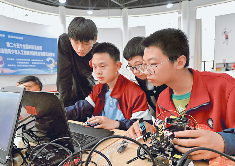 近年来，各地不断加强科学、技术、工程、数学教育，激发青少年学生对科学知识的兴趣，培养学生研究和创造能力。图为2025年5月18日，在江西省抚州市金溪县，学生在进行机器人赛前的组装、调试。 人民图片 邓兴东/摄